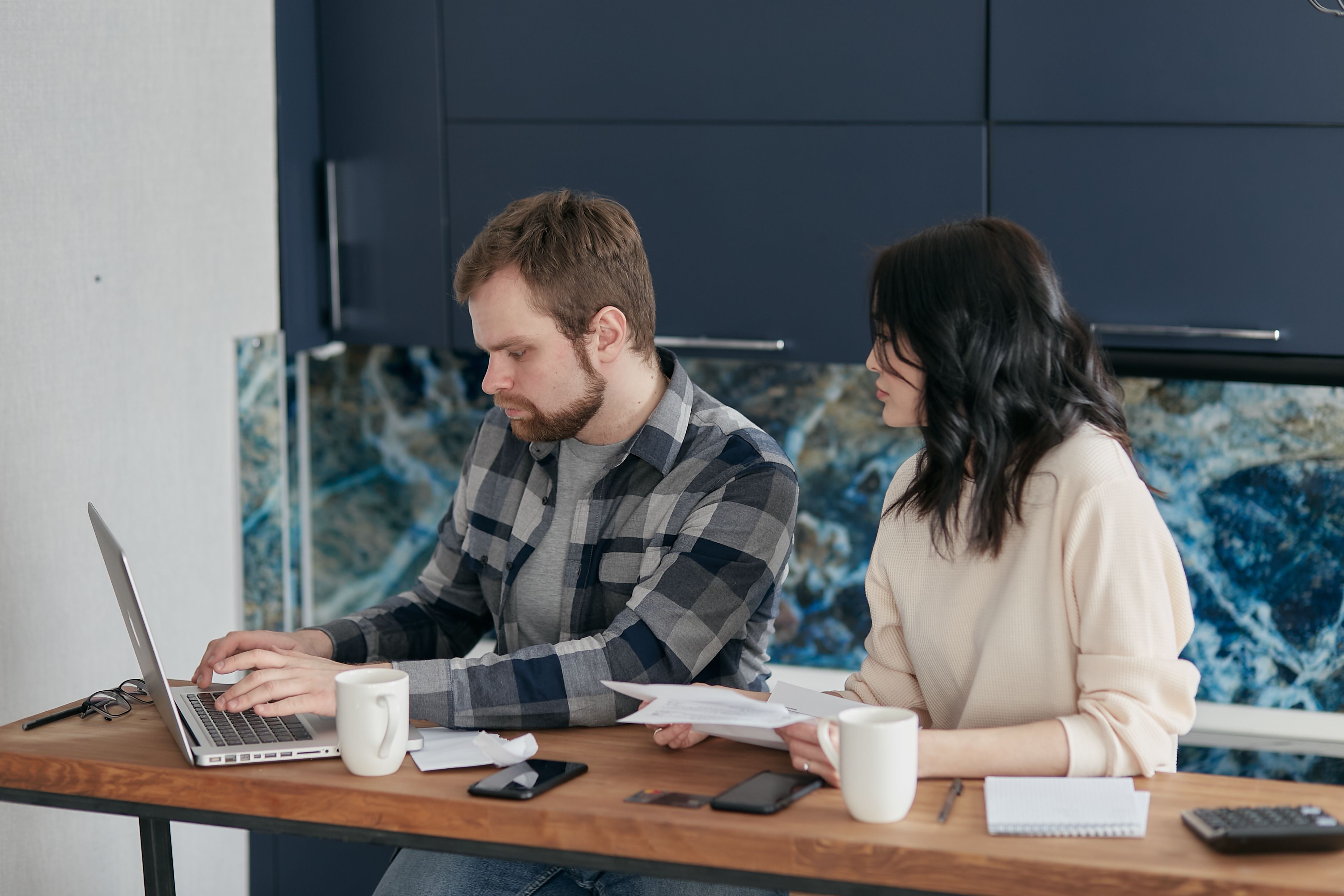 Couple reviewing household finances together at a laptop.